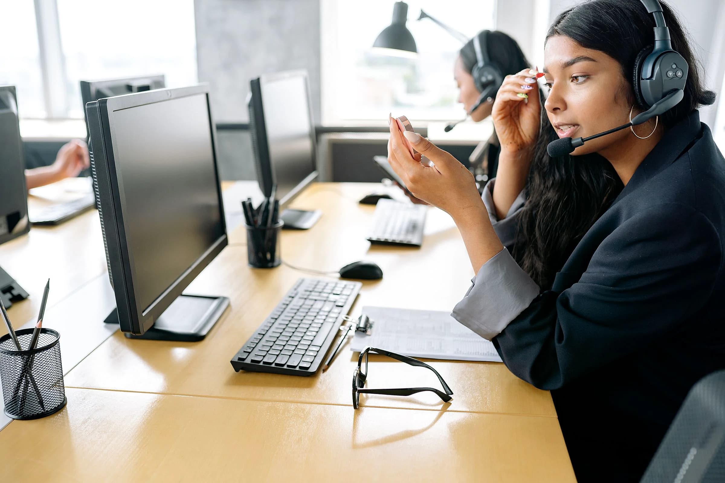 A support agent wearing a headset at her desk