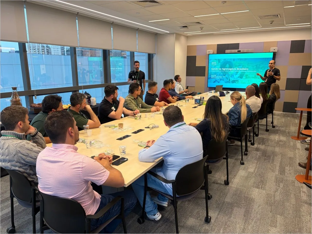 Presenting a session titled GenAI no Agronegocio Brasileiro to a group of agribusiness leaders seated around a boardroom table at the AWS office in Sao Paulo