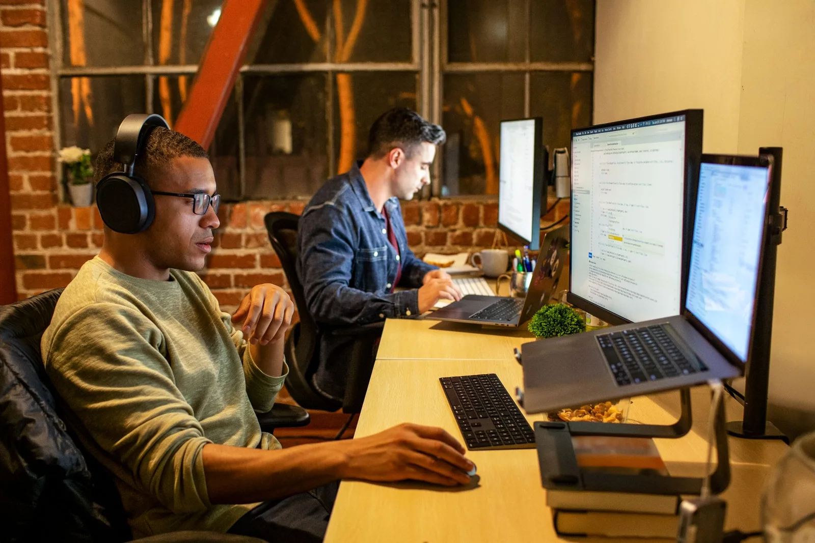 Two people sitting at desks and working at computers.